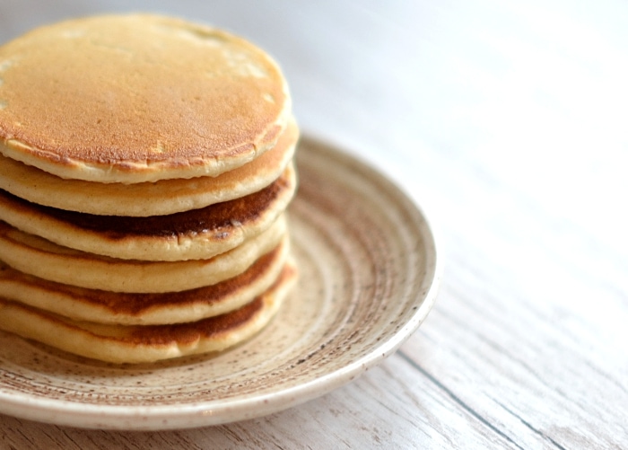 Stack of golden Drop Scones on a speckled plate