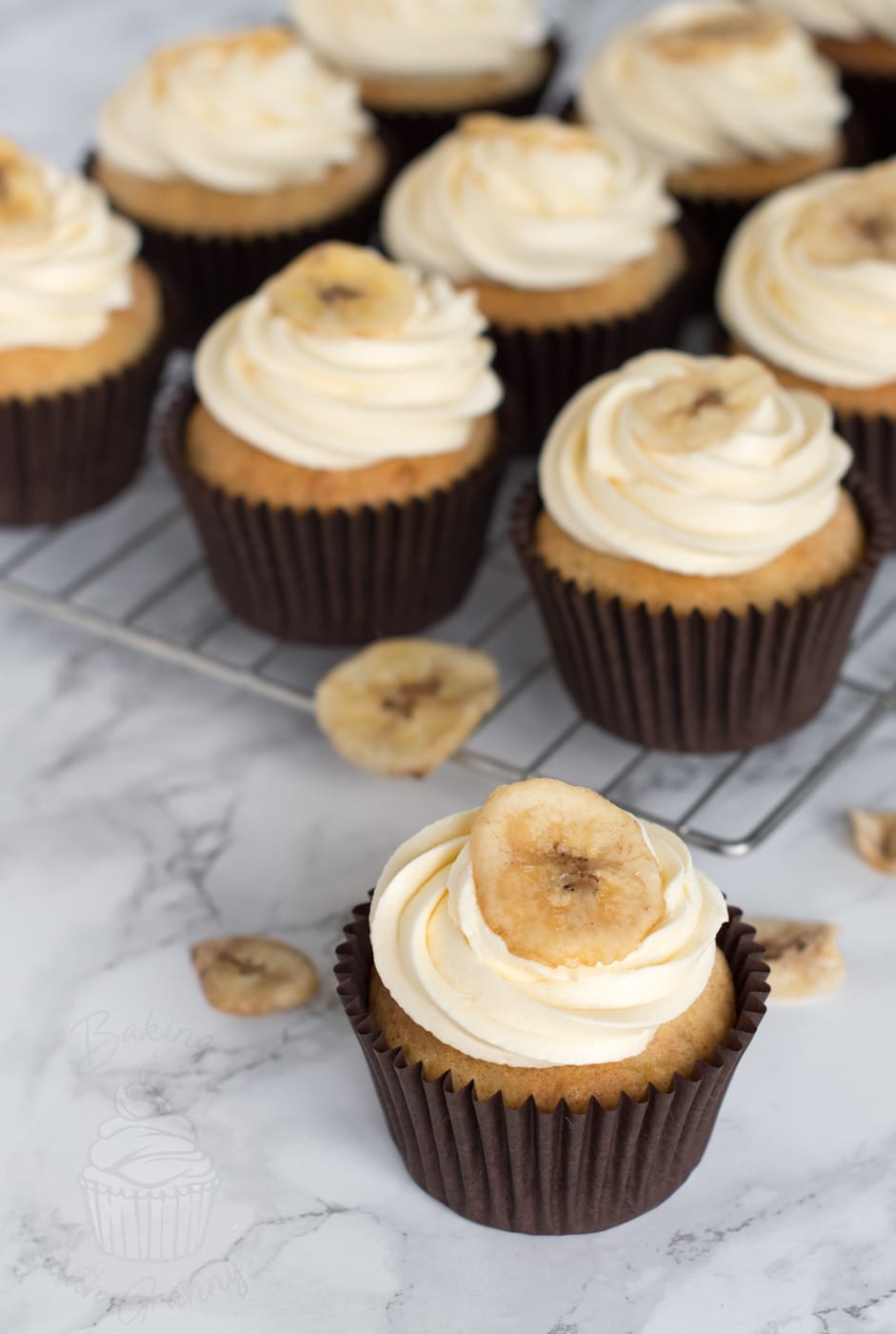 Freshly baked Banana Cupcakes topped with vanilla buttercream and dried banana chips.