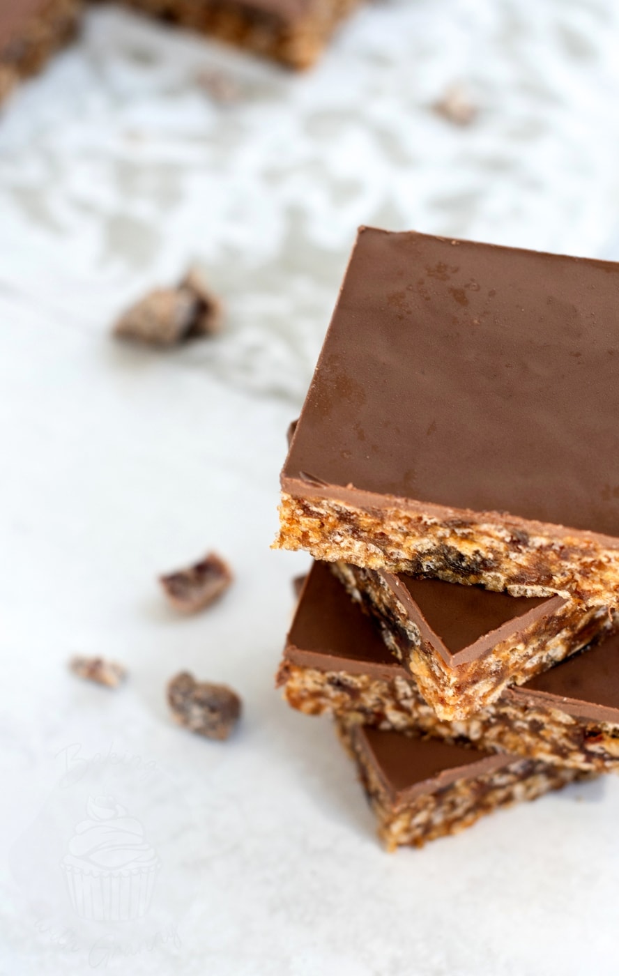 Close up of Krispy Date Slice tray bake with milk chocolate topping and chewy date and rice crispy base.