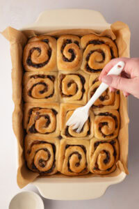 Freshly baked Chelsea Buns in a lined baking dish before glazing.