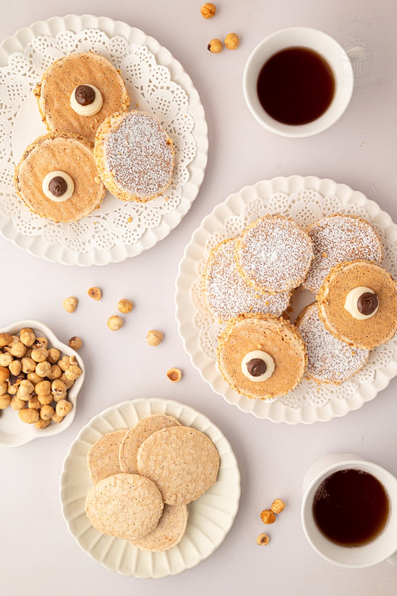 Assorted homemade cookies on white plates with coffee cups, perfect for baking with Granny®.