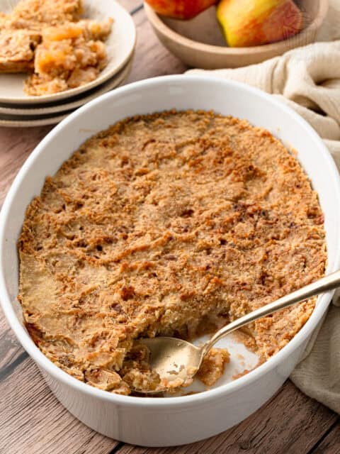 An easy apple crisp recipe baked to a perfect crisp crust, showing a gold spoon scooping out a serving.