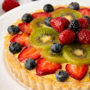 Glazed fruit tart topped with strawberries, blueberries and sliced kiwi.